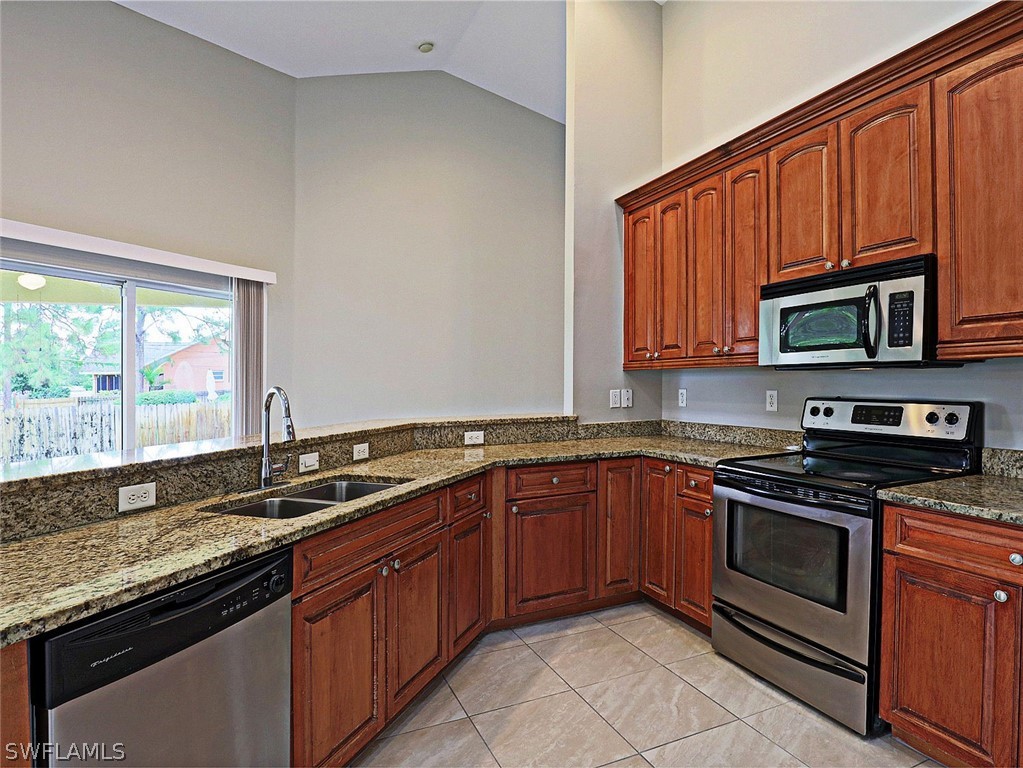 18242 Hemlock Road Fort Myers, FL 33967 - Photo 27 of 29 a kitchen with stainless steel appliances granite countertop a sink stove and microwave
