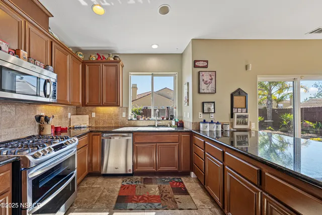 a kitchen with stainless steel appliances granite countertop a sink stove and microwave