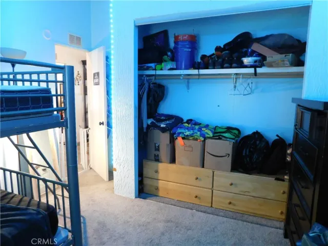 a view of closet with clothes and shoes