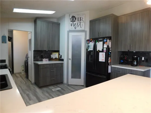 a kitchen with stainless steel appliances kitchen island granite countertop a refrigerator and a sink