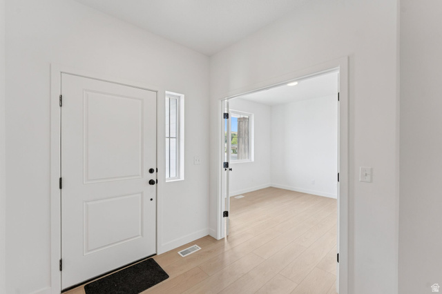 1004 West Paramount Cove South, Unit 315 Ogden, UT 84405 - Photo 15 of 42 Entryway featuring a paneled door with black hardware and light wood-finish flooring extending into a main floor office