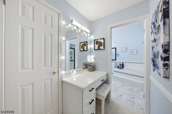 a bathroom with a tub a sink and mirror