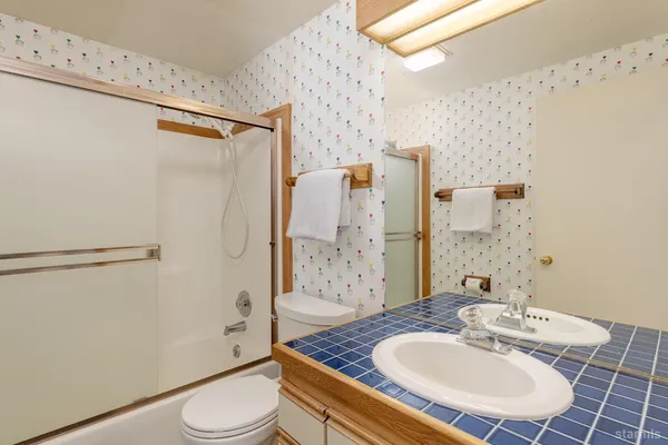 a bathroom with a sink toilet a mirror and shower