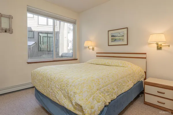 a large bed sitting in a bedroom next to a window