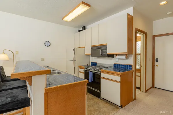 a kitchen with stainless steel appliances granite countertop a stove a refrigerator and a sink