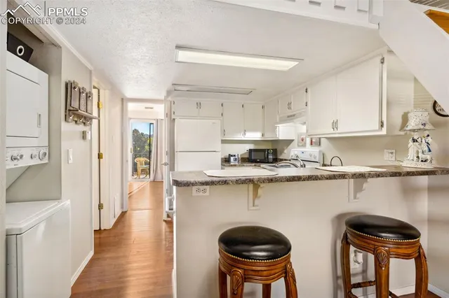 a kitchen with stainless steel appliances granite countertop a table chairs in it and wooden floors