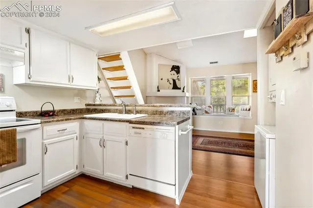 a kitchen with stainless steel appliances granite countertop a stove and white cabinets