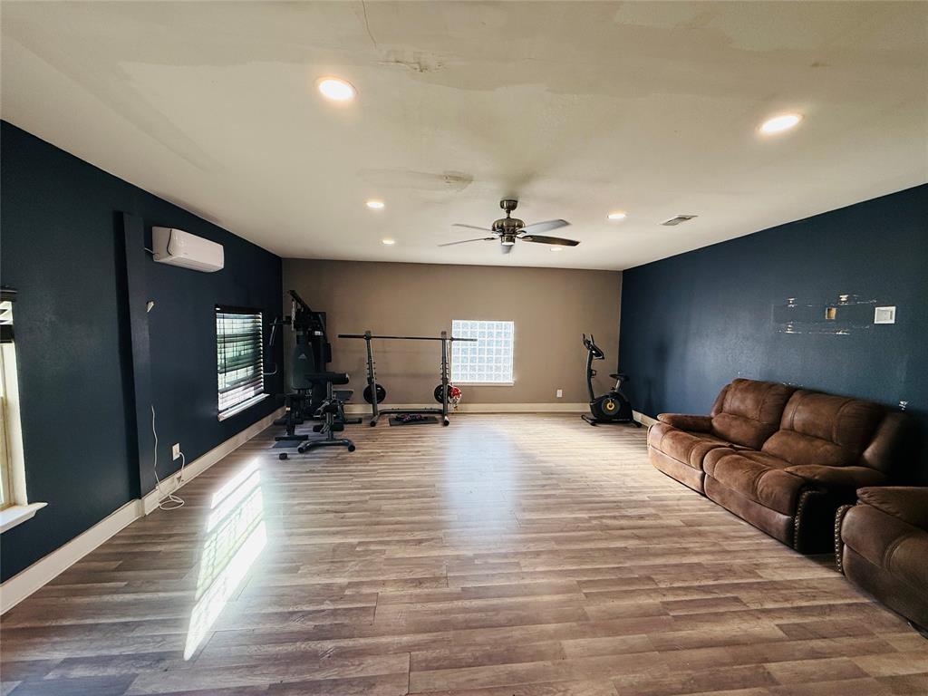 529 Northwest Private Road 147 Rice, TX 75155 - Photo 16 of 20 Workout area with wood finished floors, recessed lighting, a ceiling fan, and an accent wall