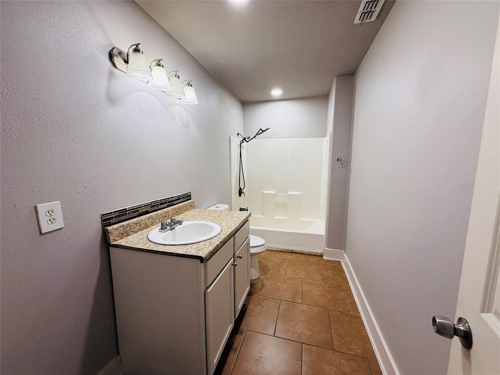 529 Northwest Private Road 147 Rice, TX 75155 - Photo 18 of 20 Bathroom featuring vanity, a textured wall, dark tile patterned flooring, shower / washtub combination, and recessed lighting
