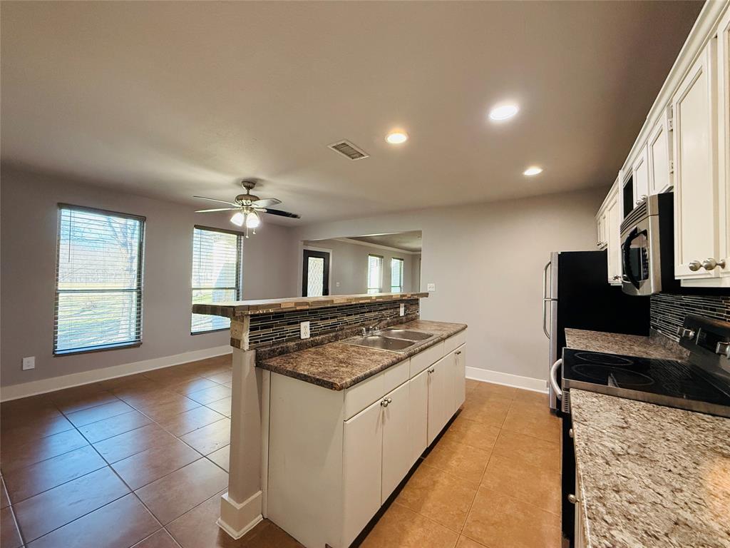 529 Northwest Private Road 147 Rice, TX 75155 - Photo 9 of 20 Kitchen featuring black range with electric stovetop, white cabinetry, recessed lighting, light tile patterned flooring, and decorative backsplash