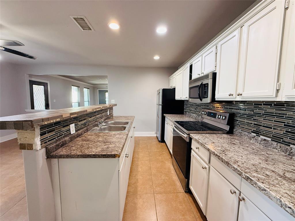 529 Northwest Private Road 147 Rice, TX 75155 - Photo 10 of 20 Kitchen with appliances with stainless steel finishes, decorative backsplash, an island with sink, white cabinets, and recessed lighting