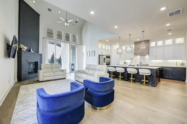 a living room with furniture a flat screen tv and kitchen view