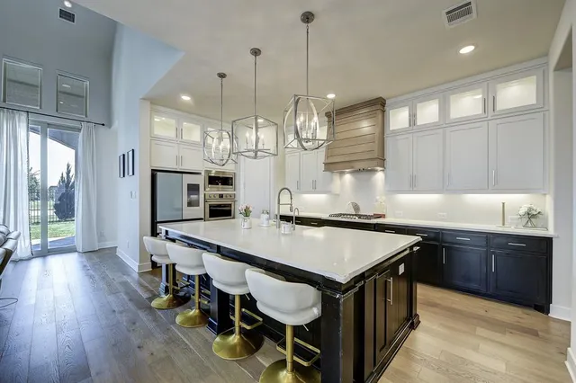 a kitchen with stainless steel appliances granite countertop a kitchen island a stove a table and chairs in it