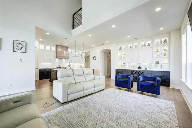 a living room with furniture a refrigerator and kitchen view