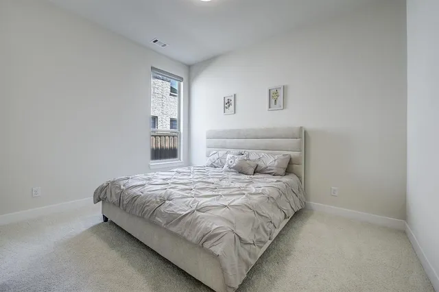 a large bed sitting in a bedroom next to a window