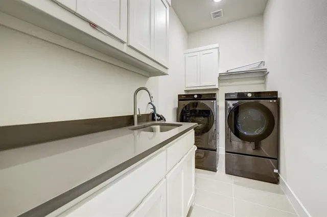 a utility room with sink dryer and washer