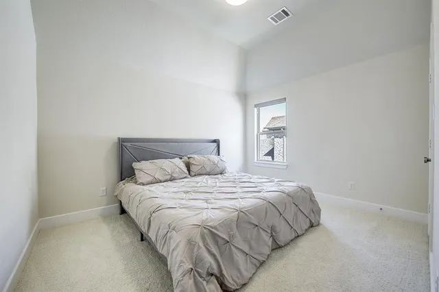 a large bed sitting in a bedroom next to a window