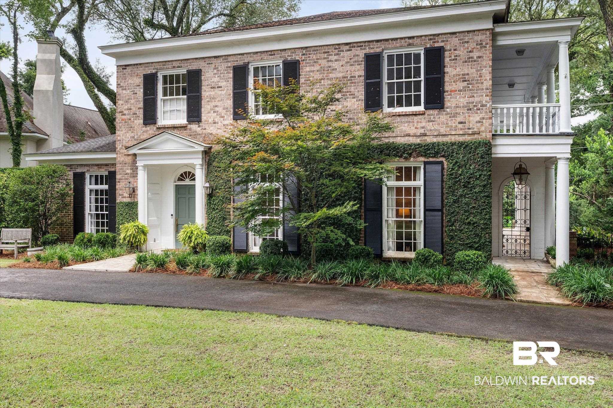 3908 Yester Place Mobile, AL 36608 - Photo 2 of 45 Brick exterior featuring a portico entry with a light blue door