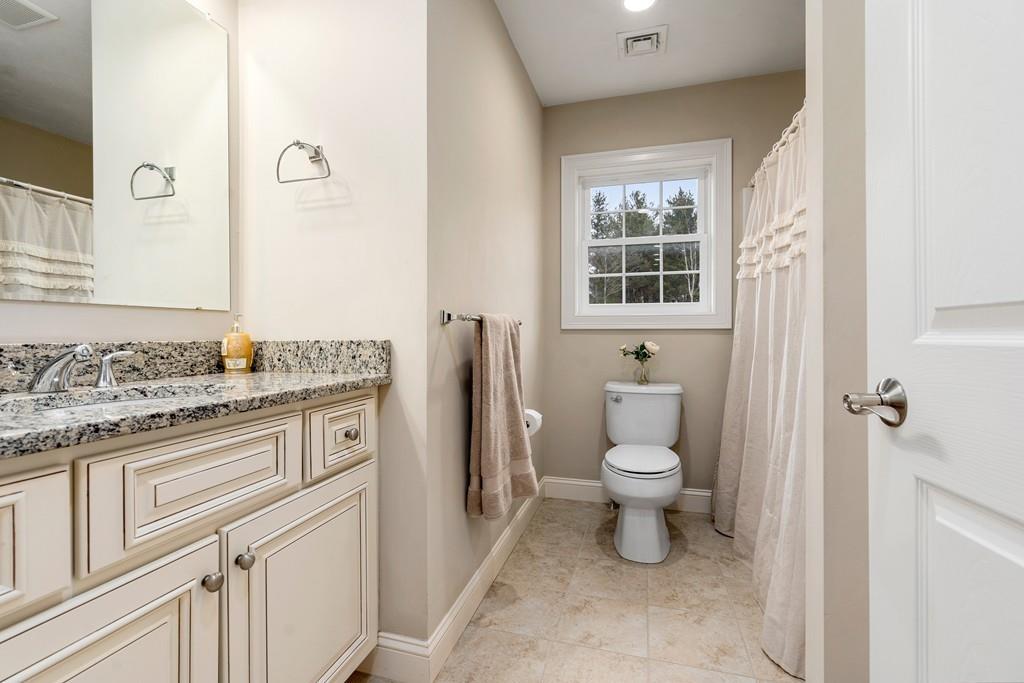 76 Deerfoot Road Southborough, MA 01772 - Photo 17 of 25 a bathroom with a granite countertop toilet a sink and a window