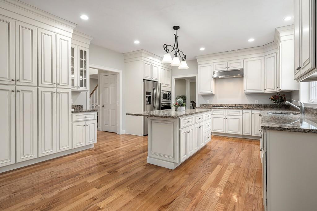 76 Deerfoot Road Southborough, MA 01772 - Photo 2 of 25 a large kitchen with stainless steel appliances kitchen island granite countertop a stove a sink dishwasher and a refrigerator with wooden floor