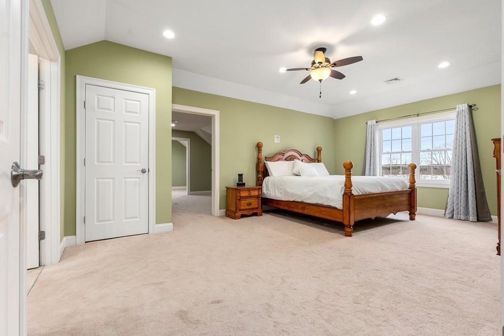 76 Deerfoot Road Southborough, MA 01772 - Photo 10 of 25 a spacious bedroom with a bed and a chandelier