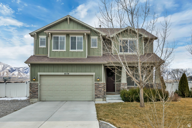 4174 Rose Springs Road Erda, UT 84074 - Photo 1 of 1 Craftsman-style home with board and batten siding, covered porch, a shingled roof, concrete driveway, and an attached garage