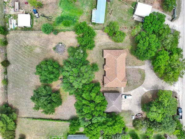 an aerial view of a house with a yard and tennis court