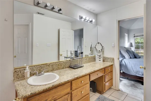 a bathroom with a granite countertop double vanity and a mirror