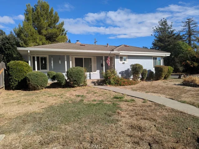 a front view of a house with a yard and potted plants