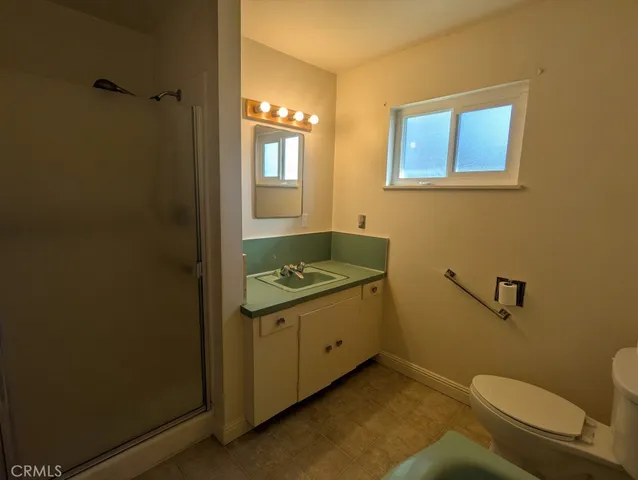 a bathroom with a granite countertop toilet and a sink