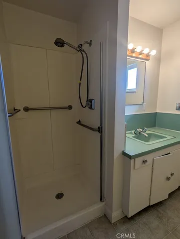a bathroom with a granite countertop shower and a sink