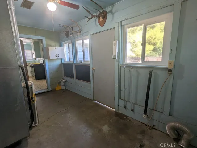 an empty room with closet and a chandelier fan