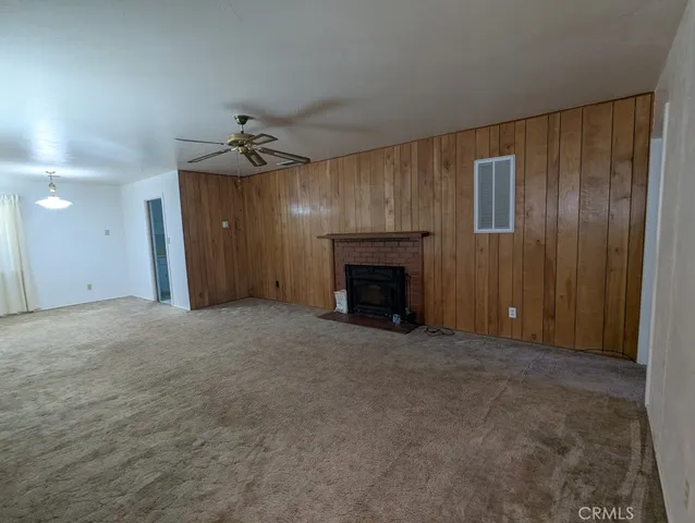an empty room with windows and fireplace