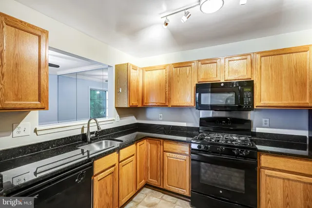 a kitchen with stainless steel appliances a sink a stove cabinets and a window