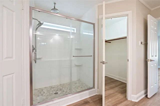 a bathroom with a glass shower door and a mirror