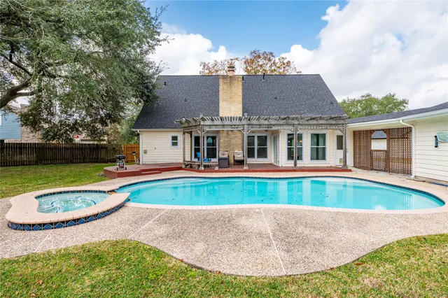 an aerial view of a house with swimming pool and yard