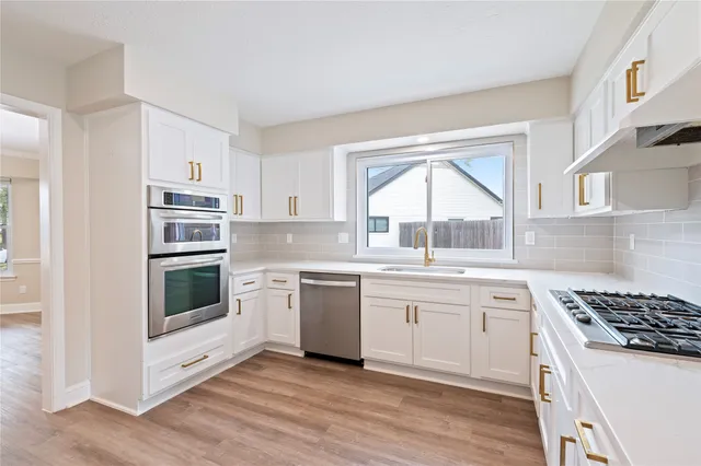 a kitchen with a stove a sink and a microwave