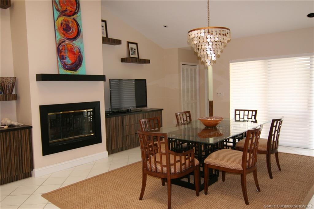6945 Southeast Harbor Circle Stuart, FL 34996 - Photo 6 of 11 a dining room with furniture a fireplace and wooden floor