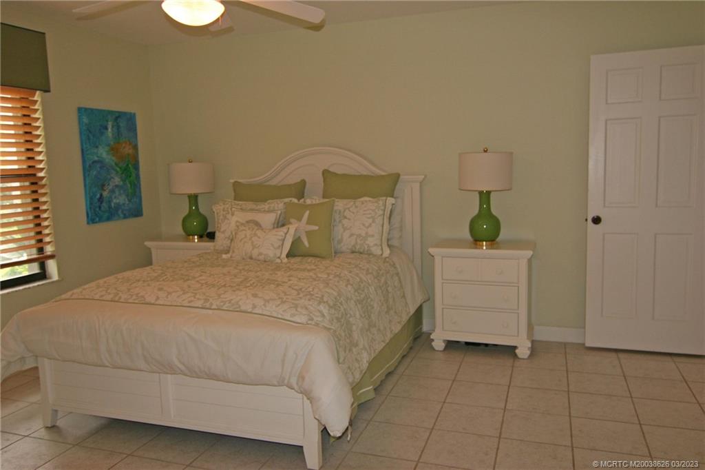 6945 Southeast Harbor Circle Stuart, FL 34996 - Photo 7 of 11 a bedroom with a bed and painting on the wall