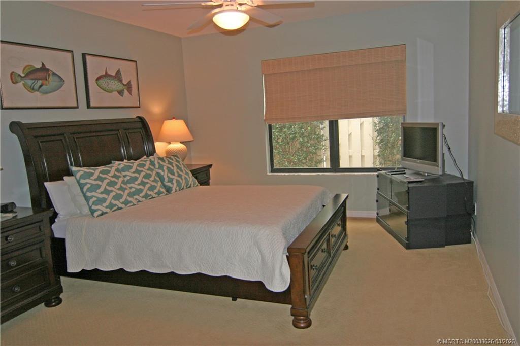 6945 Southeast Harbor Circle Stuart, FL 34996 - Photo 8 of 11 a bedroom with a bed and window
