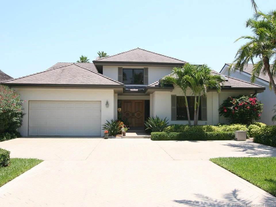 6945 Southeast Harbor Circle Stuart, FL 34996 - Photo 9 of 11 a front view of a house with a yard and garage