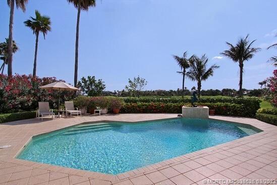 6945 Southeast Harbor Circle Stuart, FL 34996 - Photo 10 of 11 a view of a swimming pool with a table and a garden