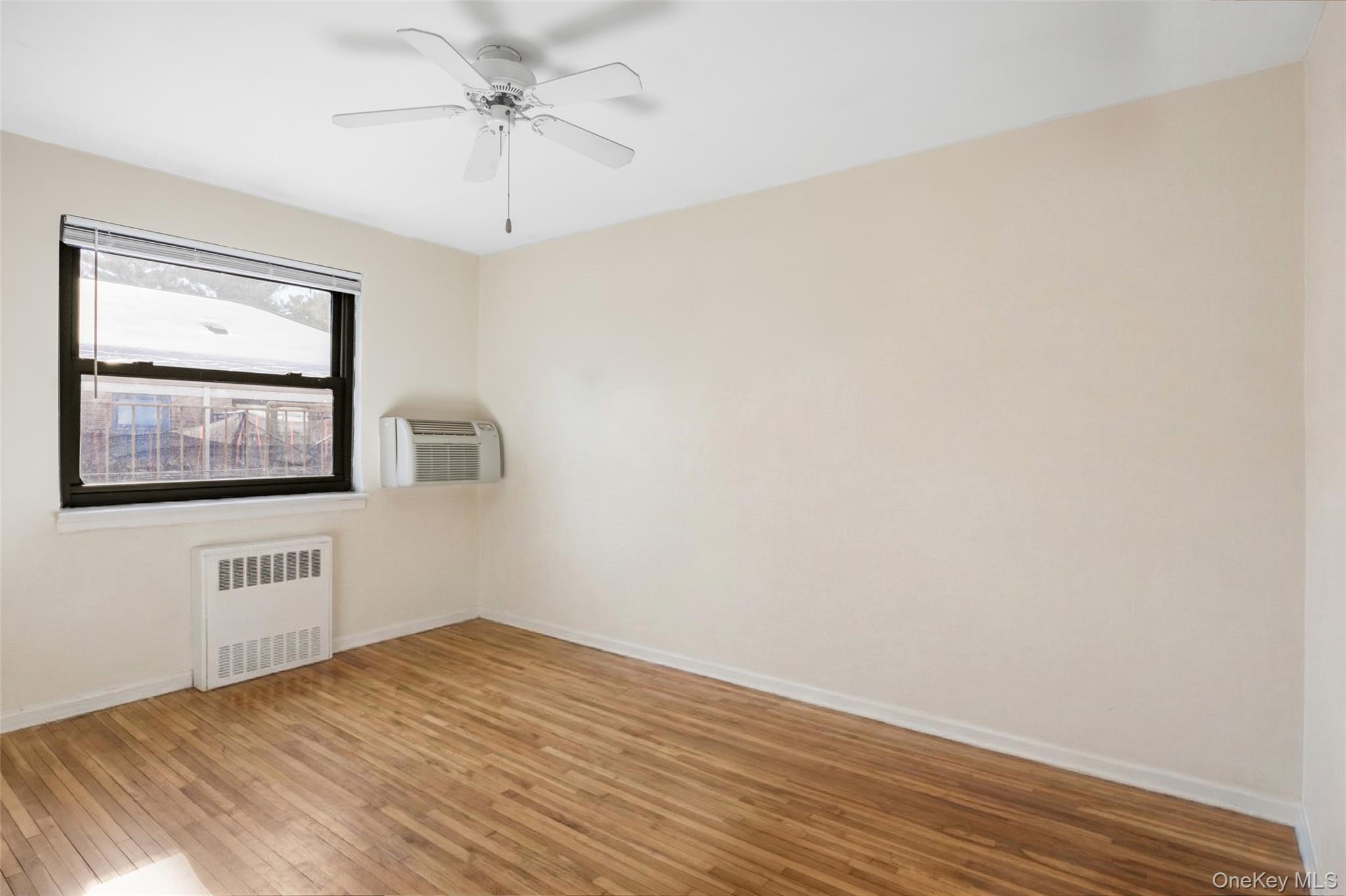 46 Terrace Circle, Unit 3F Great Neck, NY 11021 - Photo 13 of 17 a view of an empty room with window and wooden floor