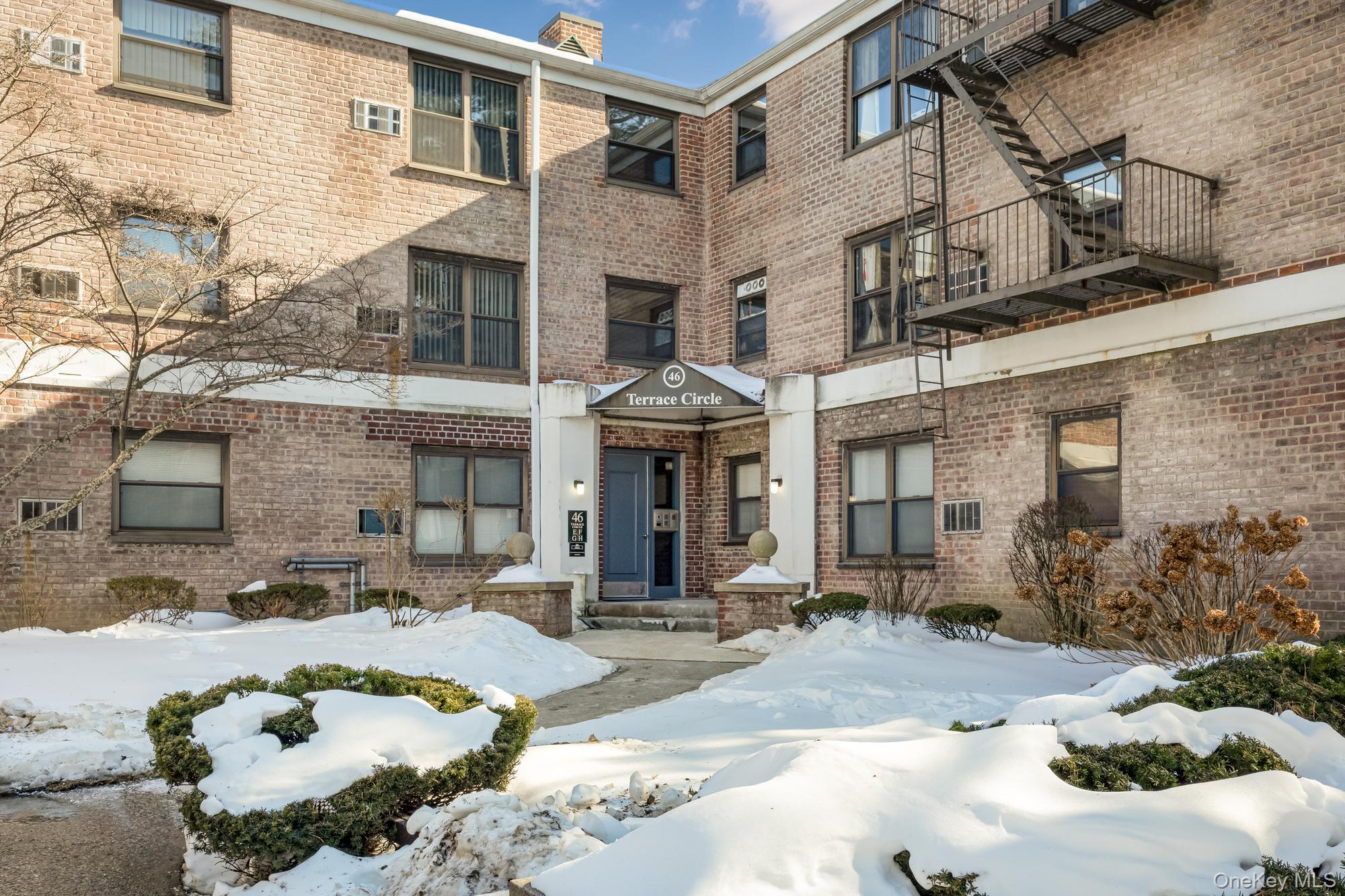 46 Terrace Circle, Unit 3F Great Neck, NY 11021 - Photo 15 of 17 a front view of a building with table and chairs