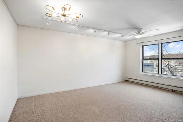 an empty room with windows and ceiling fan