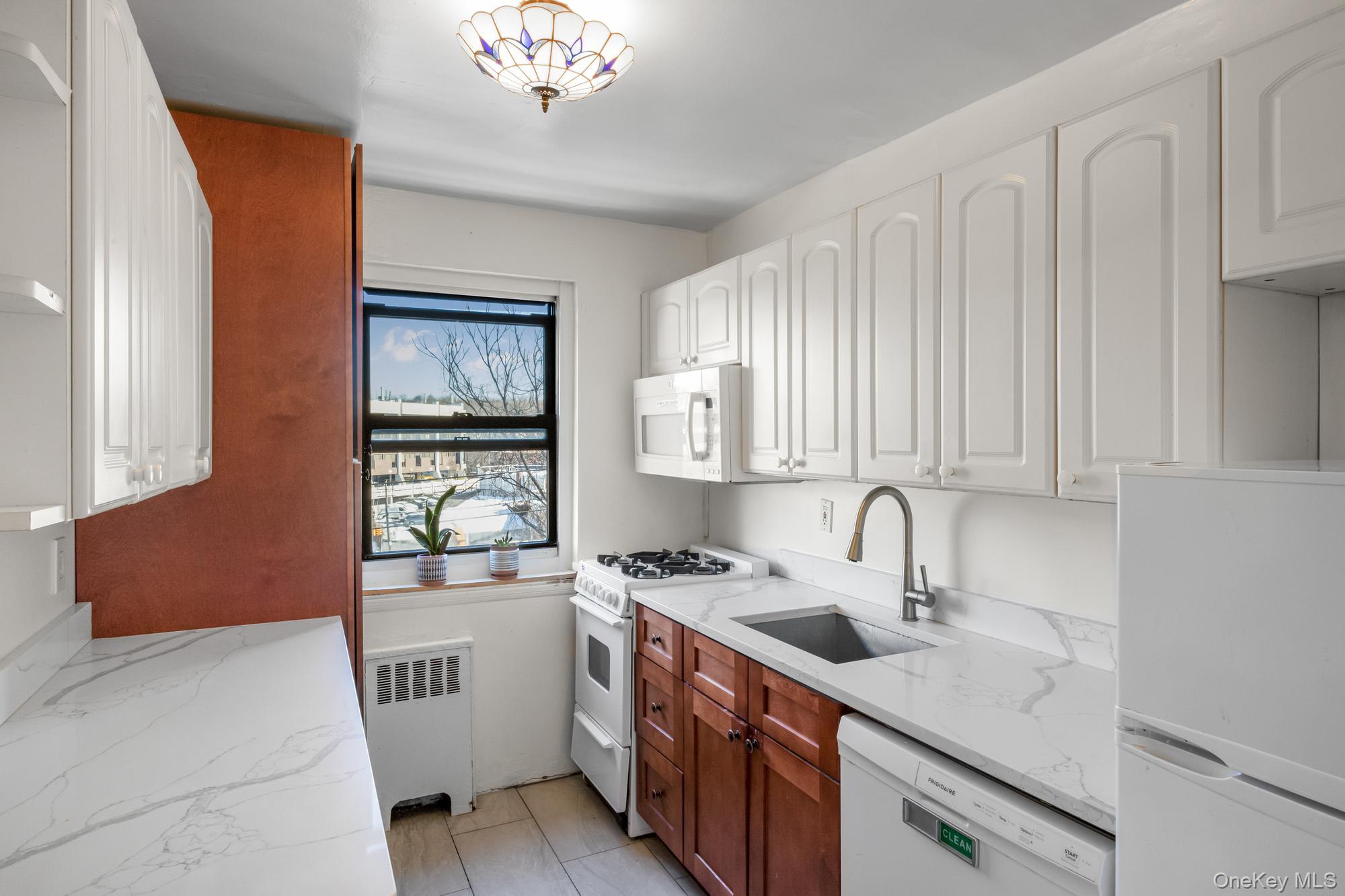 46 Terrace Circle, Unit 3F Great Neck, NY 11021 - Photo 6 of 17 a kitchen with a sink cabinets and window