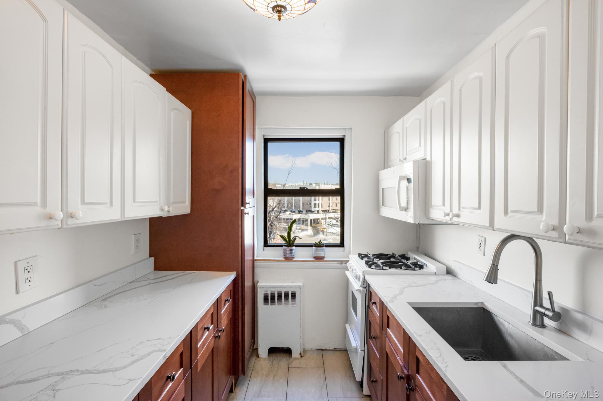 46 Terrace Circle, Unit 3F Great Neck, NY 11021 - Photo 7 of 17 a kitchen that has a sink and a stove in it