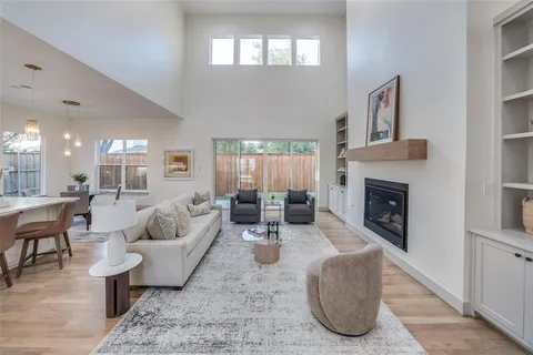 a living room with furniture a fireplace and a large window