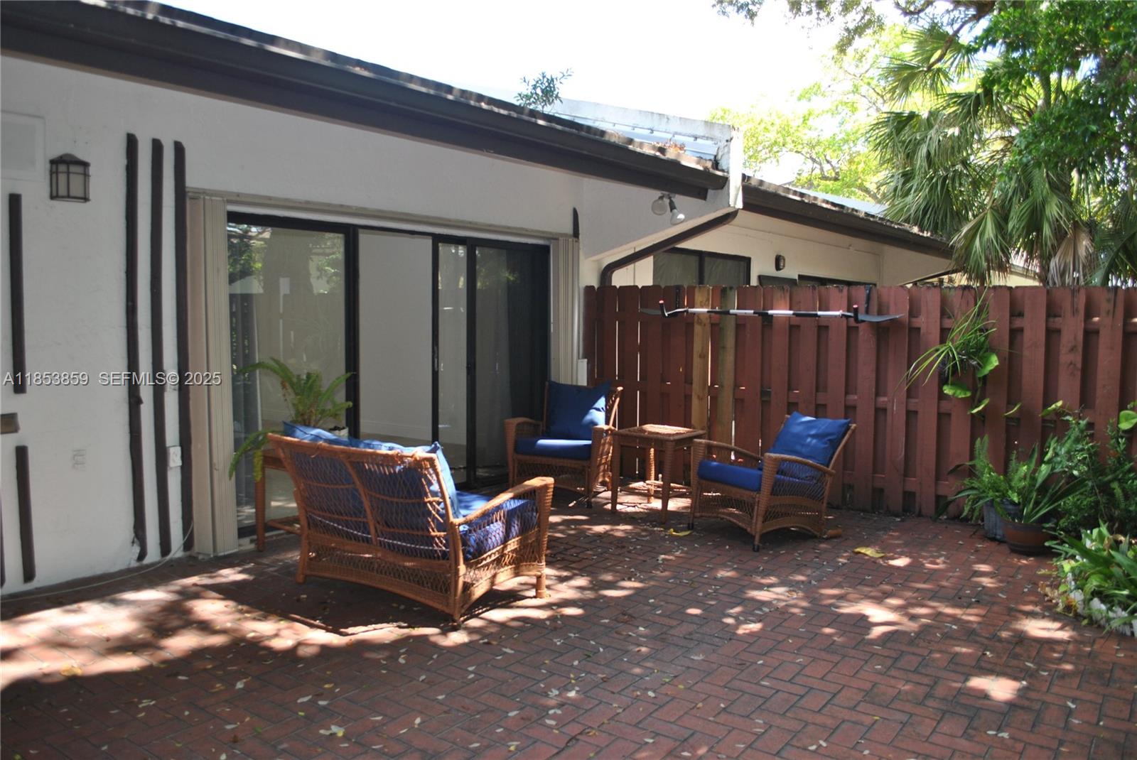 19941 Northeast 5th Court, Unit 3M Miami, FL 33179 - Photo 21 of 25 a view of a patio with table and chairs and wooden fence