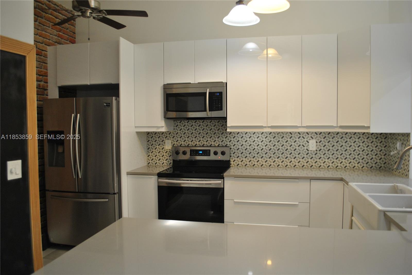19941 Northeast 5th Court, Unit 3M Miami, FL 33179 - Photo 7 of 25 a kitchen with a refrigerator sink and microwave